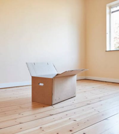 Open cardboard box on floorboard in room at home