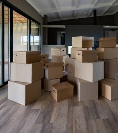 Pile of boxes to be used while packing in the living room of a house - moving house concepts